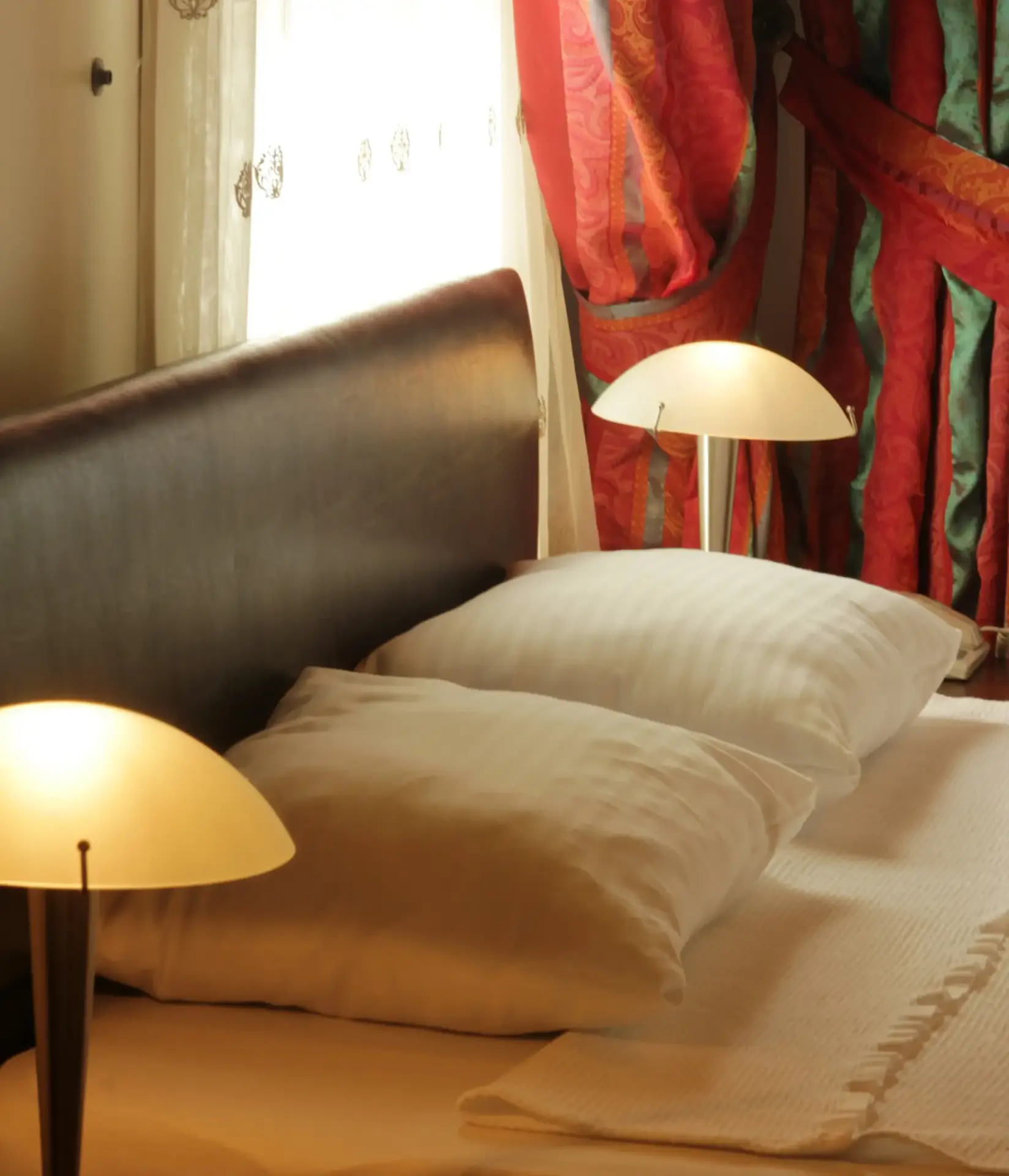 Gemütliche Beleuchtung durch eine Nachttischlampe im Hotelzimmer.